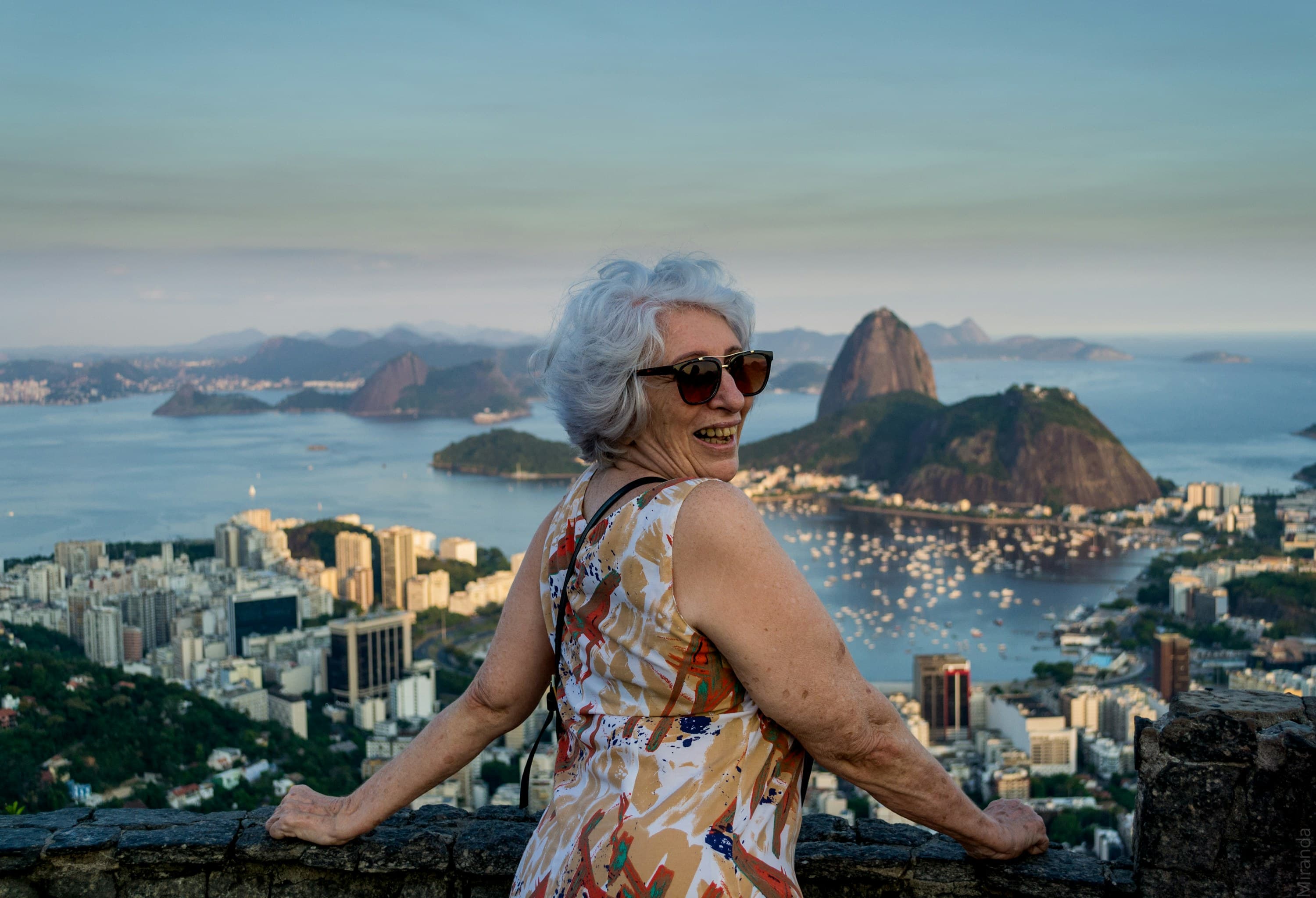 Traveler smiling above Rio de Janeiro with Sugarloaf Mountain behind
